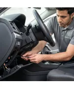 فني يقوم بتركيب جهاز تتبع (GPS) مخفي باحترافية داخل لوحة القيادة (الطبلون) للسيارة.